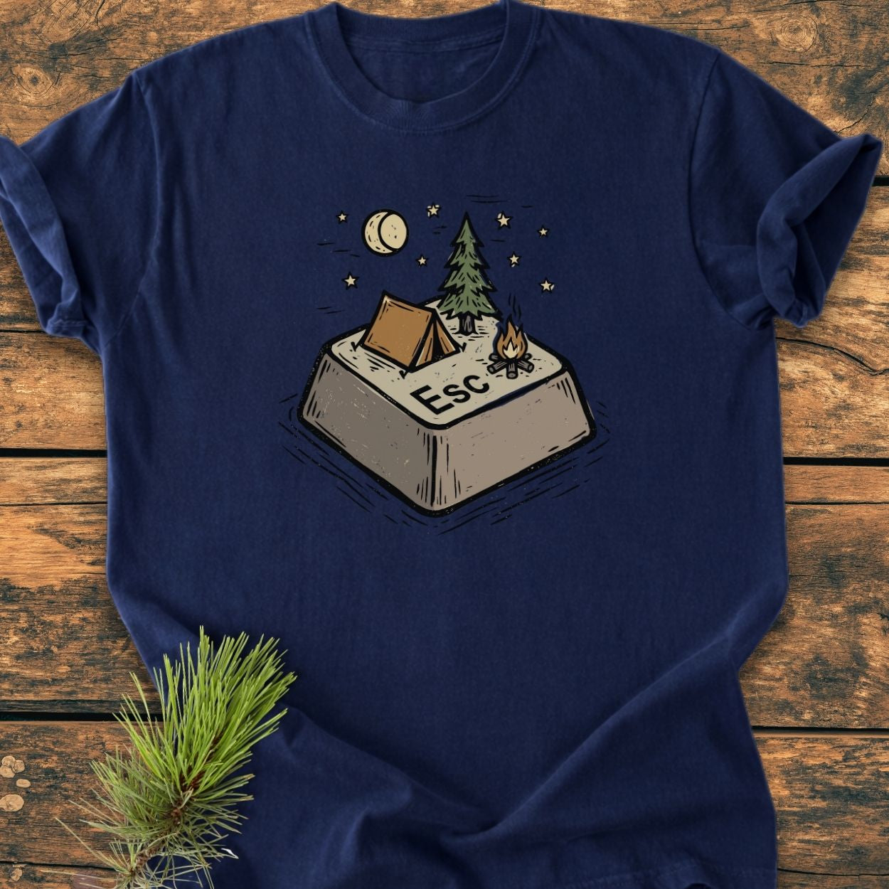 Escape - Vintage Wash Tee featuring a stylized Esc key campsite illustration, laid on wood. Garment-dyed, relaxed fit, made of soft-washed ring-spun cotton, offering comfort and durability.