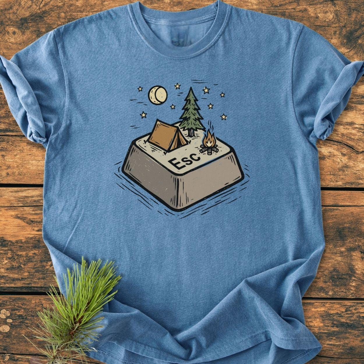 Escape - Vintage Wash Tee: Heather-blue T-shirt with a whimsical Esc key camping illustration, featuring a tent, pine tree, campfire, and starry night sky on soft, durable, garment-dyed cotton.