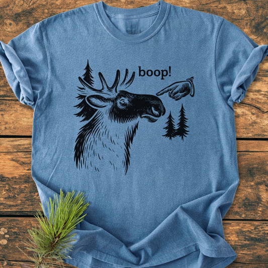 BOOP Moose Funny - Vintage Wash Tee features a moose illustration with boop! text and vintage hand design on a light-blue, soft-washed t-shirt. Fir-tree silhouettes and pine needles accentuate the design.