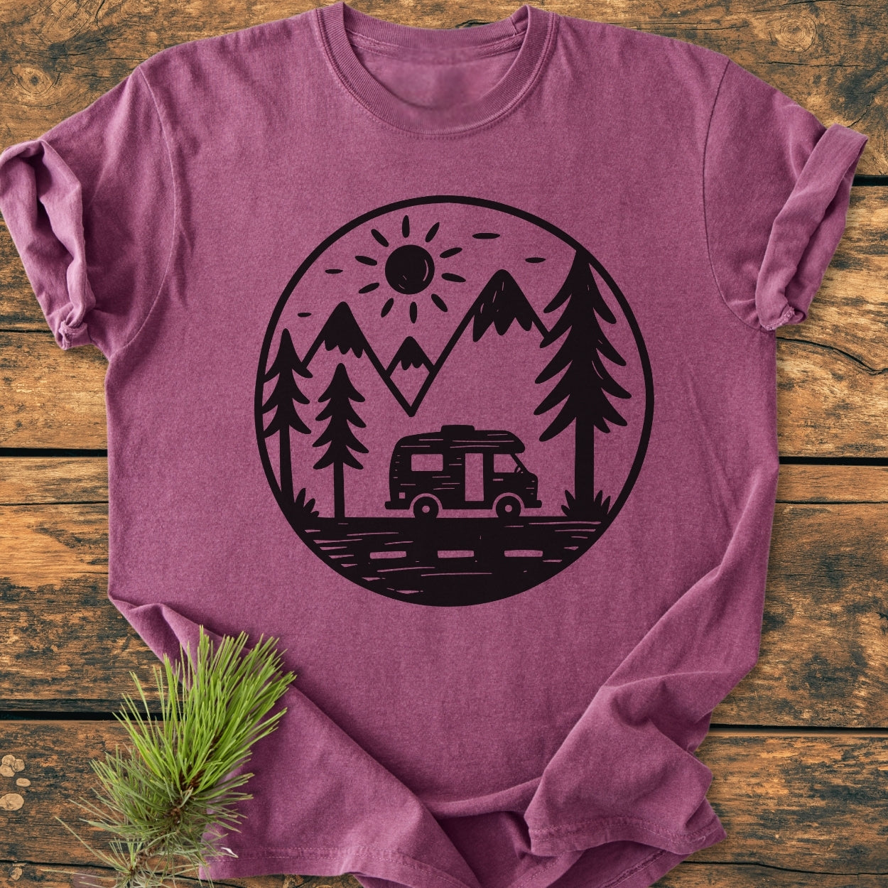 Freedom Is Found Outside - Vintage Wash Tee featuring a black outdoor scene graphic on a folded purple-heather T-shirt, laid on wood, with a nearby pine branch accentuating its rustic charm.