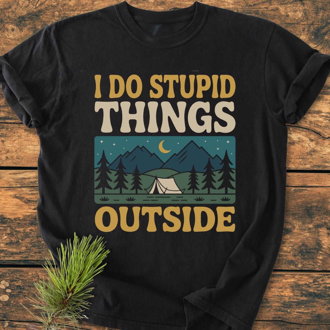 I Do Stupid Things Outside - Vintage Wash Tee features a retro-style print with a nighttime camping scene, including a crescent moon, stars, pine trees, and a tent, on a black T-shirt.