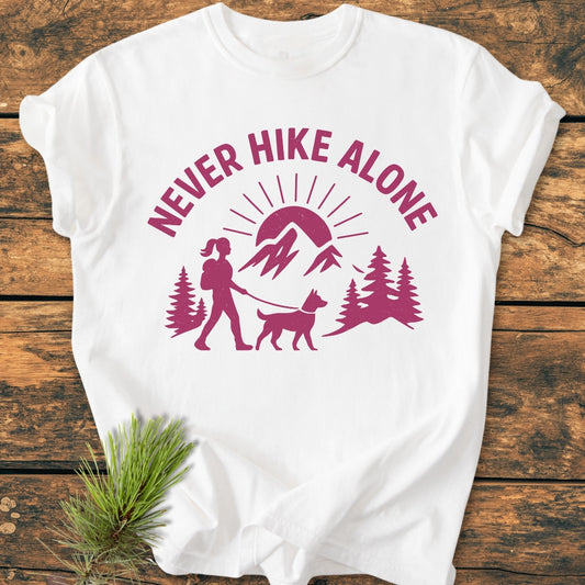 Never Hike Alone Dog Mom - Vintage Wash Tee features a hiker and dog graphic, silhouetted by mountains and sun. Crafted from soft, pre-shrunk cotton with relaxed fit, perfect for everyday wear.