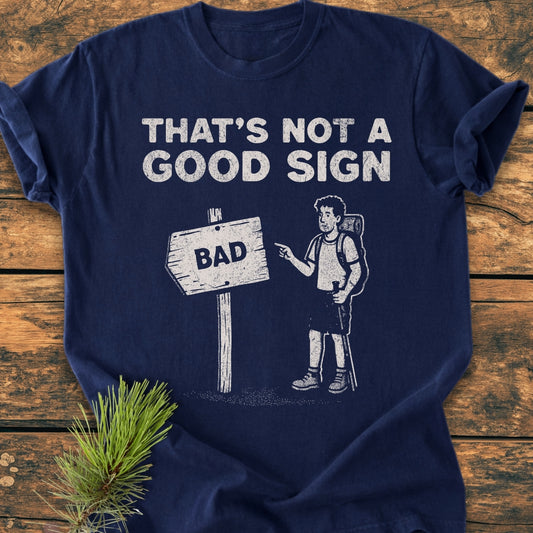 Bad Sign - Vintage Wash Tee features a humorous graphic of a hiker and a BAD sign, printed on a relaxed-fit, navy-blue T-shirt, known for its soft, pre-shrunk, ring-spun cotton fabric.