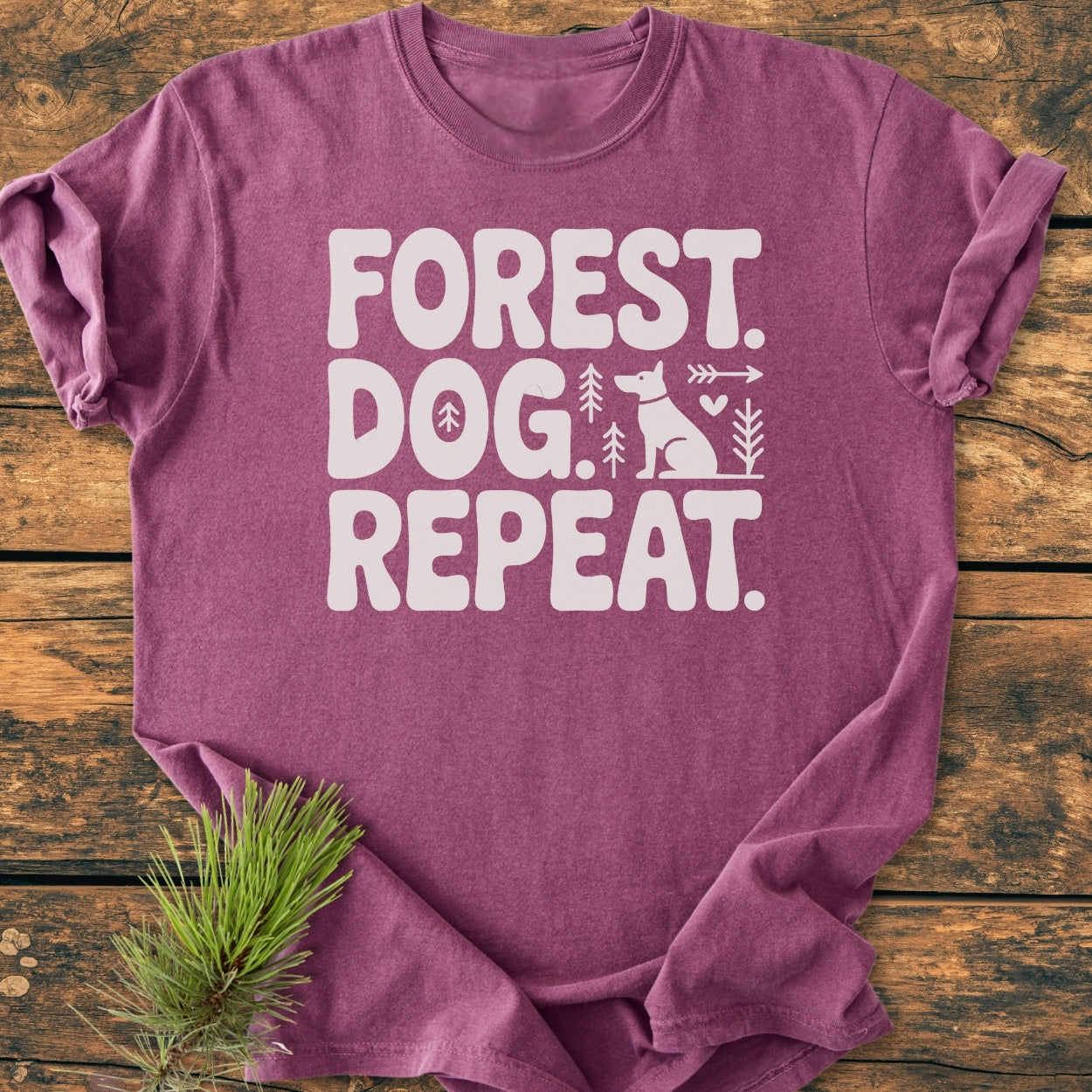 Forest Dog Repeat - Vintage Wash Tee: A heather-purple crew-neck T-shirt with FOREST. DOG. REPEAT. printed in white, featuring a dog silhouette with pine-tree icons, displayed on rustic wood.