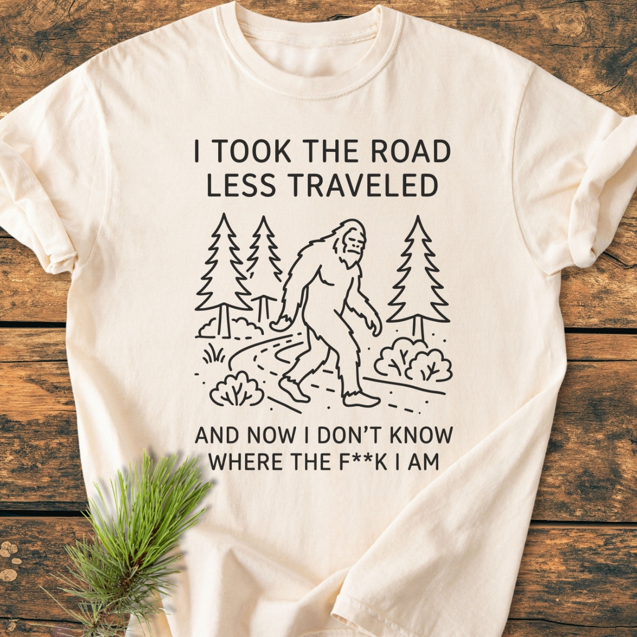 I Took The Road Less Traveled - Vintage Wash Tee with Bigfoot graphic, featuring bold text above and below the image. The tee is laid flat, showcasing its relaxed fit and durable stitching.