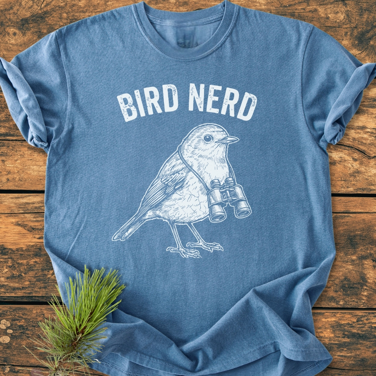 Bird Nerd - Vintage Wash Tee features a songbird with binoculars and 'BIRD NERD' slogan, styled on a rustic background, highlighting its comfortable, relaxed fit and durable design.