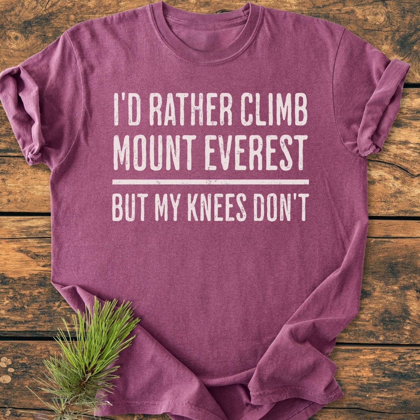 “I’d Rather Climb Mount Everest - Vintage Wash Tee” in heathered plum, displayed flat on wood, with white slogan and pine sprig accent. Soft, relaxed fit, durable, and pre-shrunk for everyday comfort.