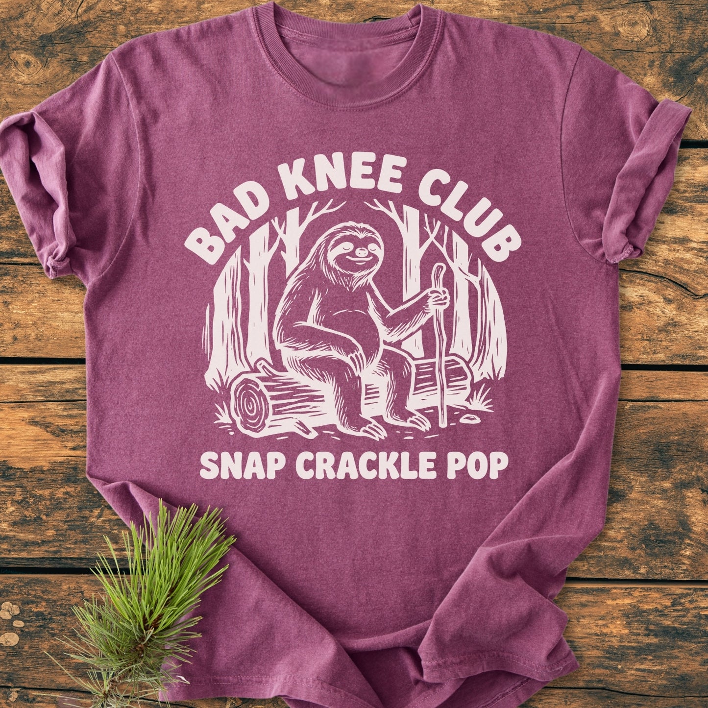 The Bad Knee Club - Vintage Wash Tee features a sloth line-drawing with text on a soft, relaxed fit T-shirt, ideal for daily wear, showcasing durability and comfort.