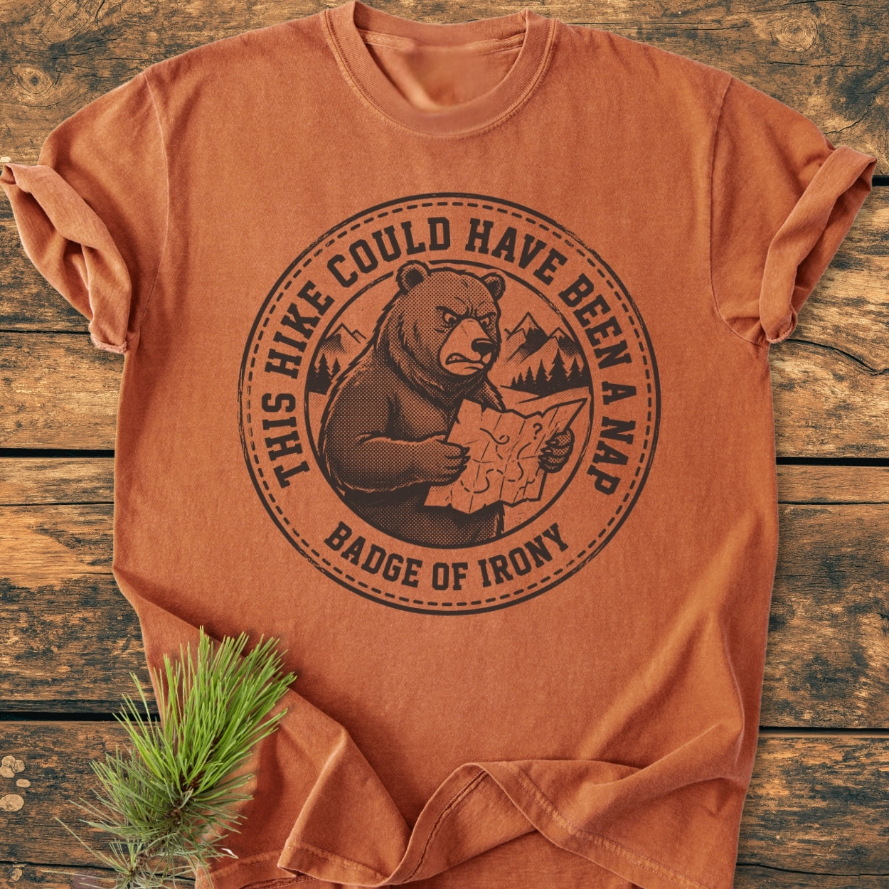 Could Have Been A Nap - Vintage Wash Tee: Features an annoyed bear with a map on an orange-rust shirt, laid flat on wood. Includes 'Badge of Irony' text, offering a cozy, relaxed fit.