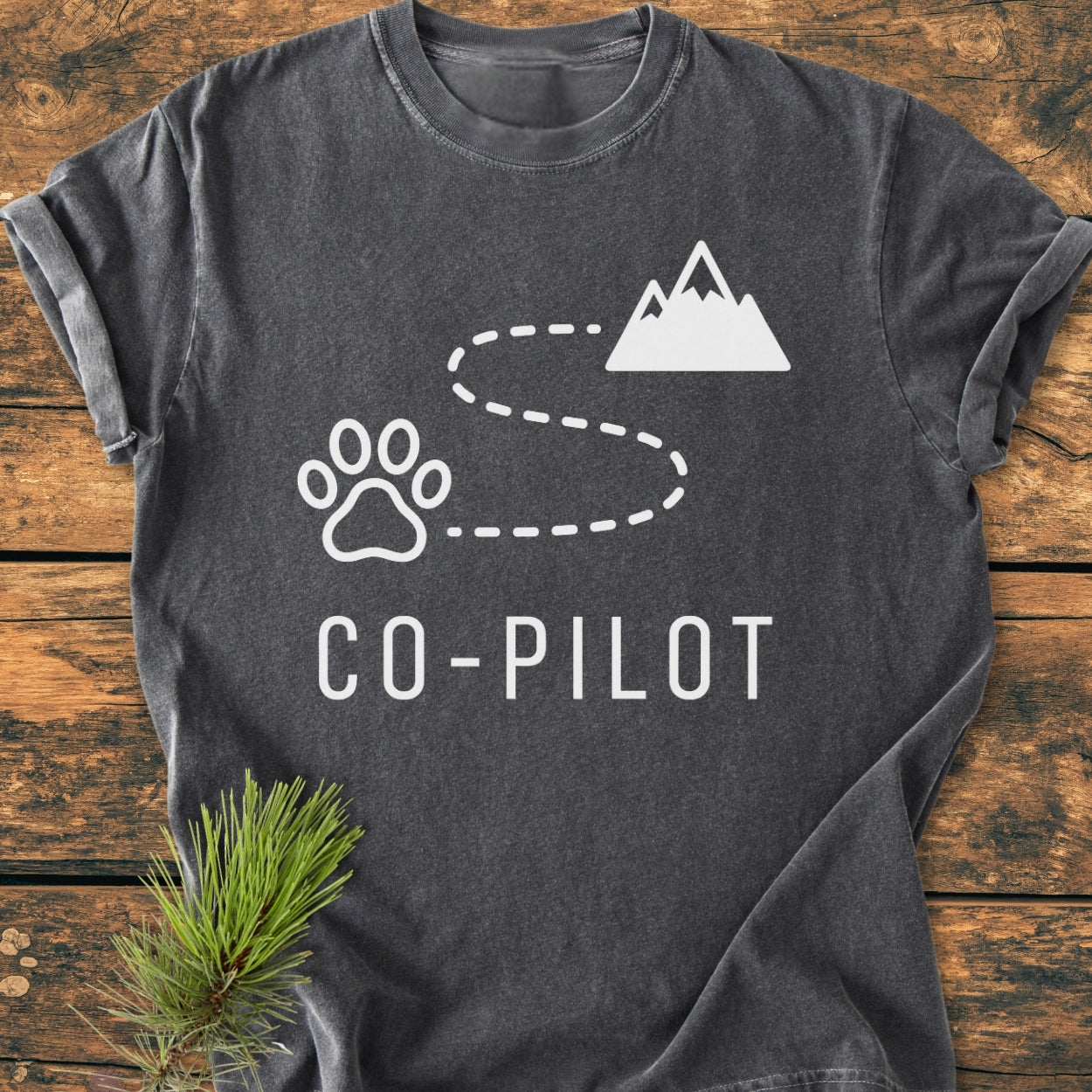 Co-Pilot Dog - Vintage Wash Tee with a playful design featuring a paw print, mountain silhouette, and dashed trail, printed in white on a charcoal-gray, soft, and durable T-shirt.