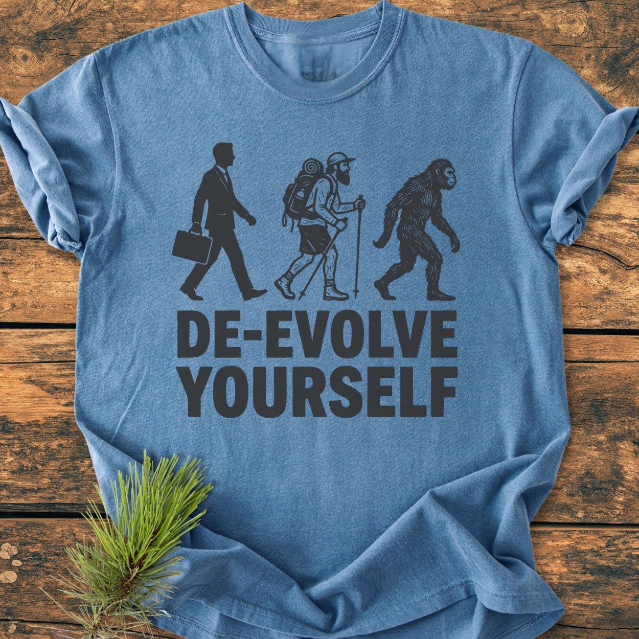 De-Evolve Yourself - Vintage Wash Tee features a light-blue fabric with a black graphic of a reverse-evolution sequence, highlighting the slogan DE-EVOLVE YOURSELF, showcasing its relaxed, durable design.
