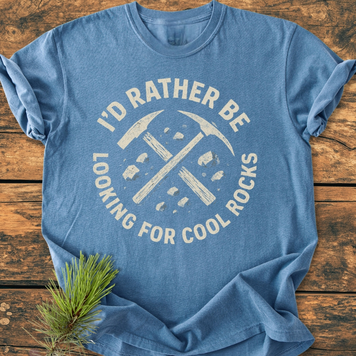 Heather-blue I'd Rather... Rockhound - Vintage Wash Tee with a distressed white graphic of crossed pick-axes and rocks, laid flat, showcasing its relaxed fit and soft garment-dyed fabric.