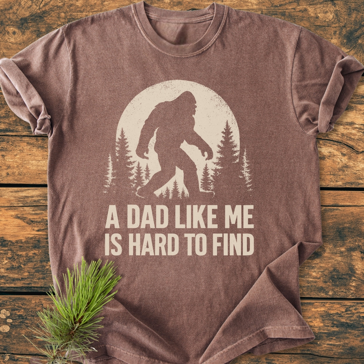 Vintage Bigfoot Dad - Vintage Wash Tee features a Bigfoot silhouette in a moonlit forest with the phrase “A DAD LIKE ME IS HARD TO FIND” on a cozy, ring-spun cotton T-shirt.