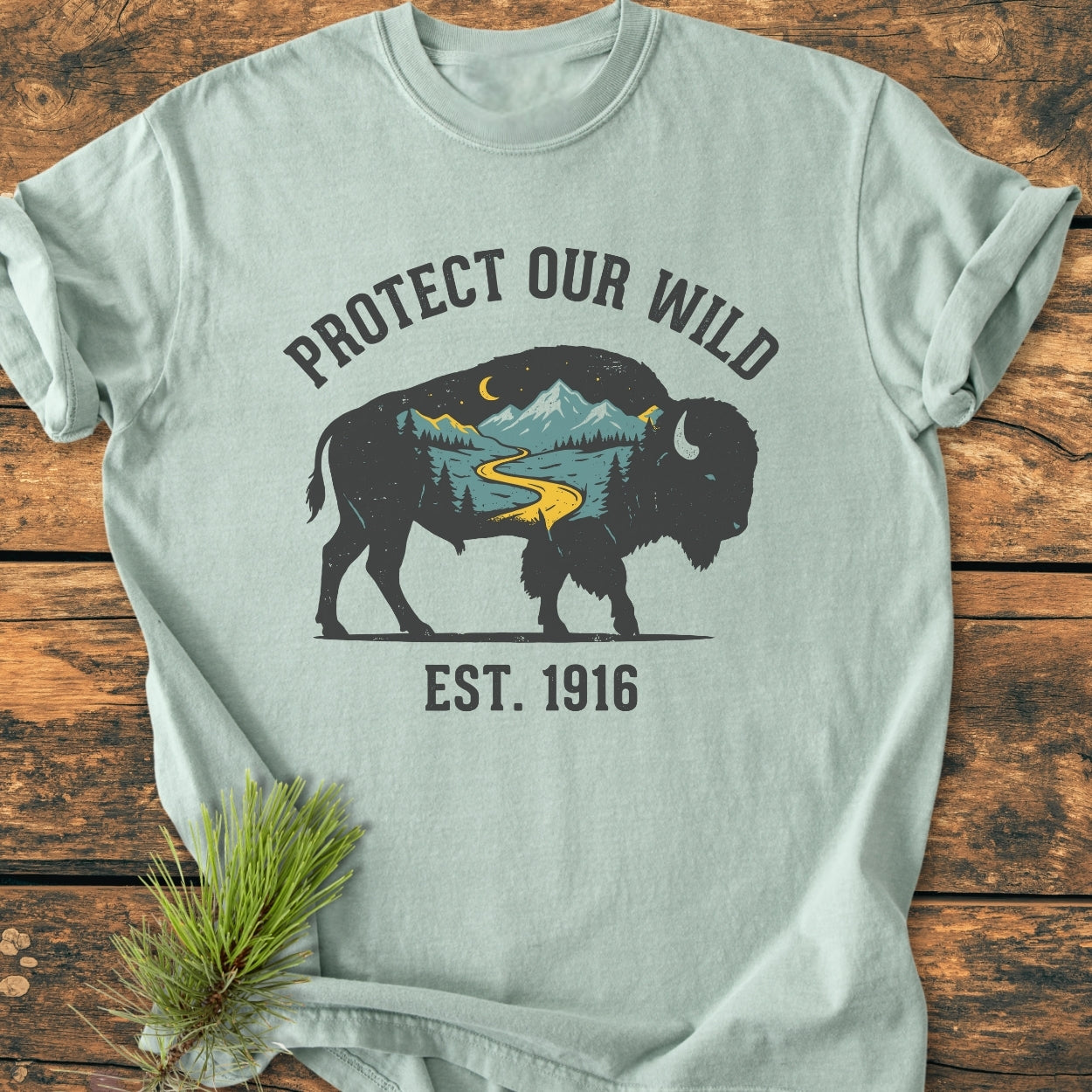 Protect Our Wild - Vintage Wash Tee features a bison silhouette with wilderness graphics on a mint-green shirt, emphasizing durability and comfort with its 100% ring-spun cotton and relaxed fit.