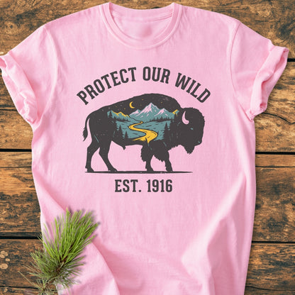Protect Our Wild - Vintage Wash Tee features a bison silhouette with a nature scene, PROTECT OUR WILD text above, and EST. 1916 below, displayed on a light pink, soft-washed, ring-spun cotton T-shirt.