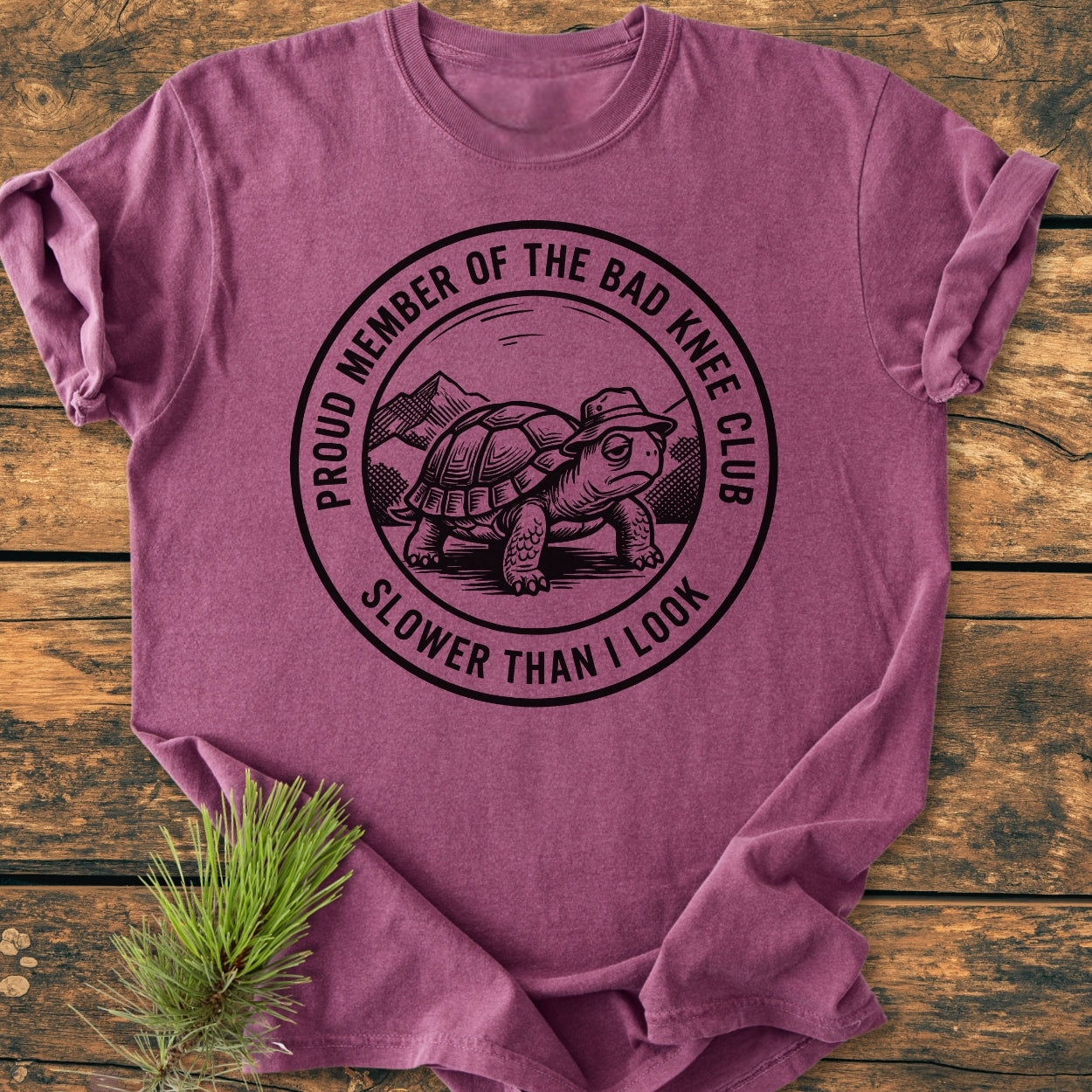 Bad Knee Club - Vintage Wash Tee features a turtle graphic with text, PROUD MEMBER OF THE BAD KNEE CLUB, on a heathered purple T-shirt, showcasing relaxed fit and durability.