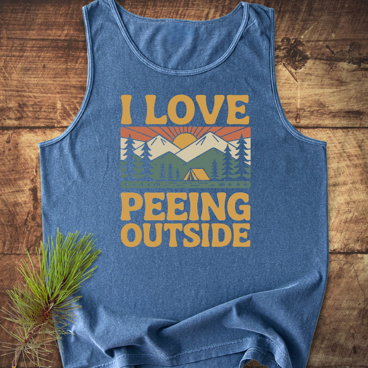 I Love Peeing Outside Tank Top features a retro camping graphic with mountains and a tent, made from 100% ring-spun US cotton, offering a relaxed fit and sustainable design.