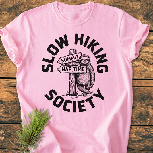 Slow Hiking Society - Vintage Wash Tee features a cartoon sloth with a trail sign, on soft pink fabric. Made of pre-shrunk, 100% ring-spun cotton for a relaxed fit.