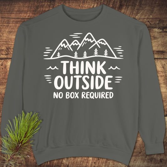 Think Outside Sweatshirt on rustic wood, featuring white mountain and tree line-drawing with slogan. Gray, crew-neck with relaxed fit, showcasing luxurious garment-dyed fabric and simple outdoor-inspired design.