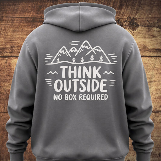 Think Outside Hoodie BACKPRINT showcases a mountain and pine tree line-art with the slogan THINK OUTSIDE NO BOX REQUIRED on a soft, garment-dyed unisex hoodie, ideal for outdoor adventures.