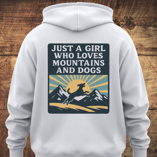 Just A Girl Who Loves Dogs Hoodie BACKPRINT features a stylized mountain scene with a sun and leaping dog silhouette, and the slogan, capturing the essence of nature and adventure in a cozy unisex fit.