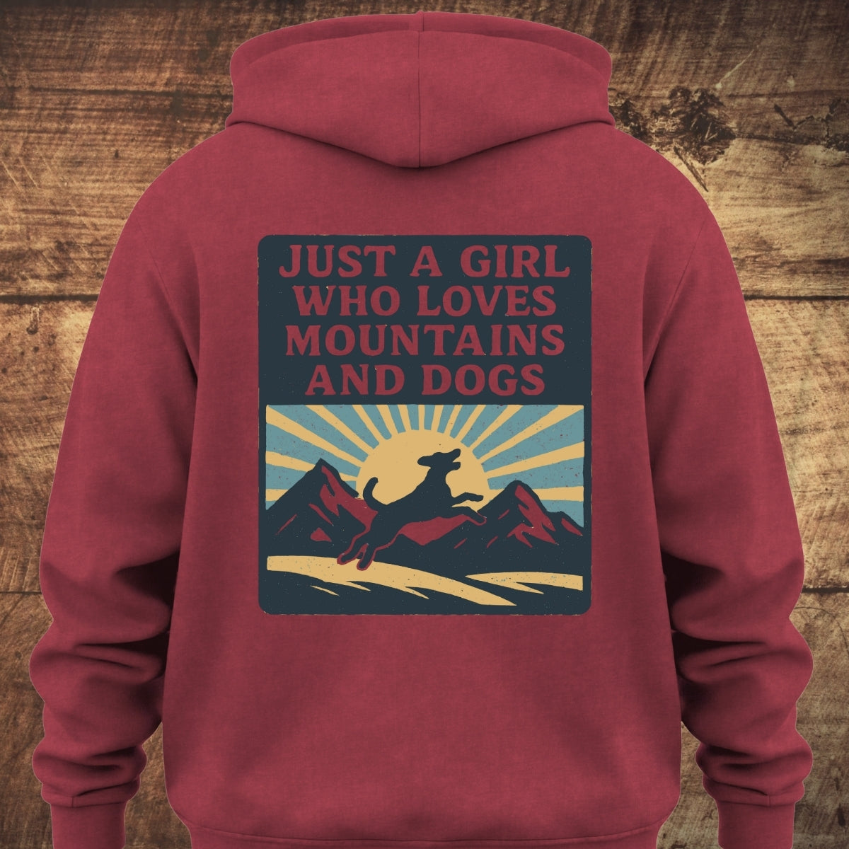 Back view of the Just A Girl Who Loves Dogs Hoodie BACKPRINT. Features a retro graphic with a dog leaping in front of mountains and a rising sun, embodying adventure and comfort.