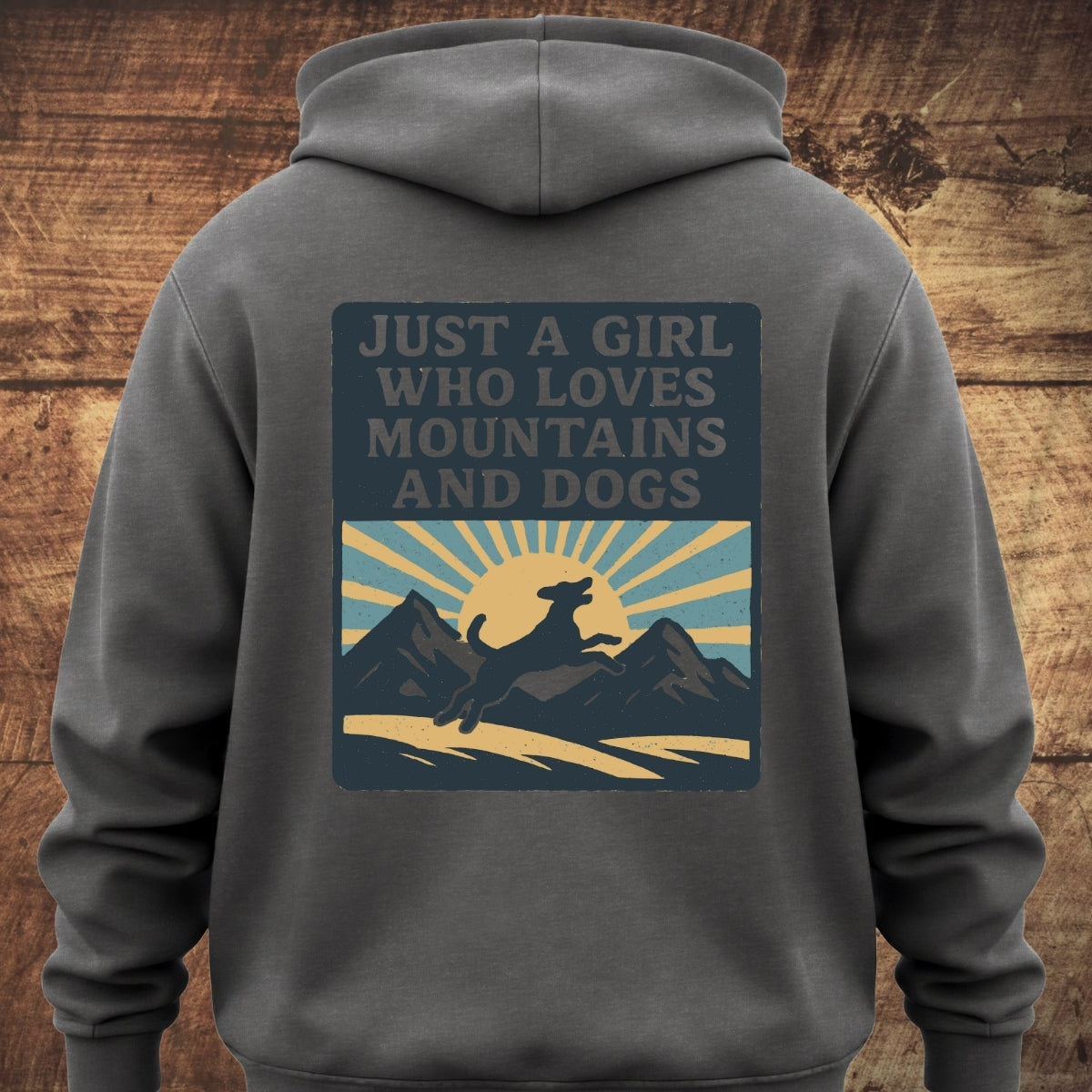 Just A Girl Who Loves Dogs Hoodie BACKPRINT showing a vintage-style graphic with sunrays, mountains, and a leaping dog, perfect for cozy adventures with its relaxed unisex fit and garment-dyed softness.