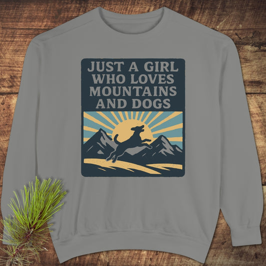 Just A Girl Who Loves Dogs Sweatshirt displayed flat, featuring a mountain and dog graphic. Made with luxurious ring-spun cotton-polyester blend, it offers a relaxed fit and garment-dyed comfort.