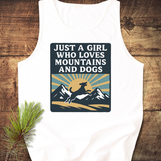 Just A Girl Who Loves Dogs Tank Top featuring a retro-style graphic of a sun, mountains, and a leaping dog, laid on wood, highlighting its relaxed fit and sustainable design.