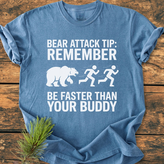 Bear Attack Tip Be Fast - Vintage Wash Tee features a humorous graphic of a bear chasing stick figures, text printed in white on a blue tee, laid on wooden surface.