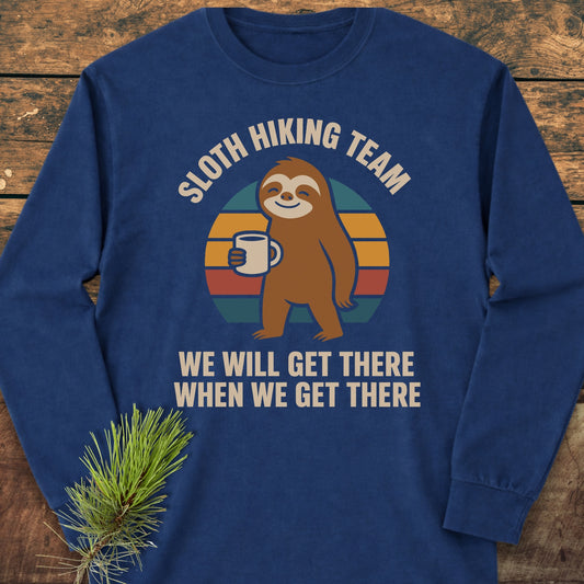 Sloth Hiking Team Long-Sleeve Tee featuring a cartoon sloth with mug and humorous text on a retro sunset background, crafted from 100% ring-spun cotton for a soft, relaxed fit.
