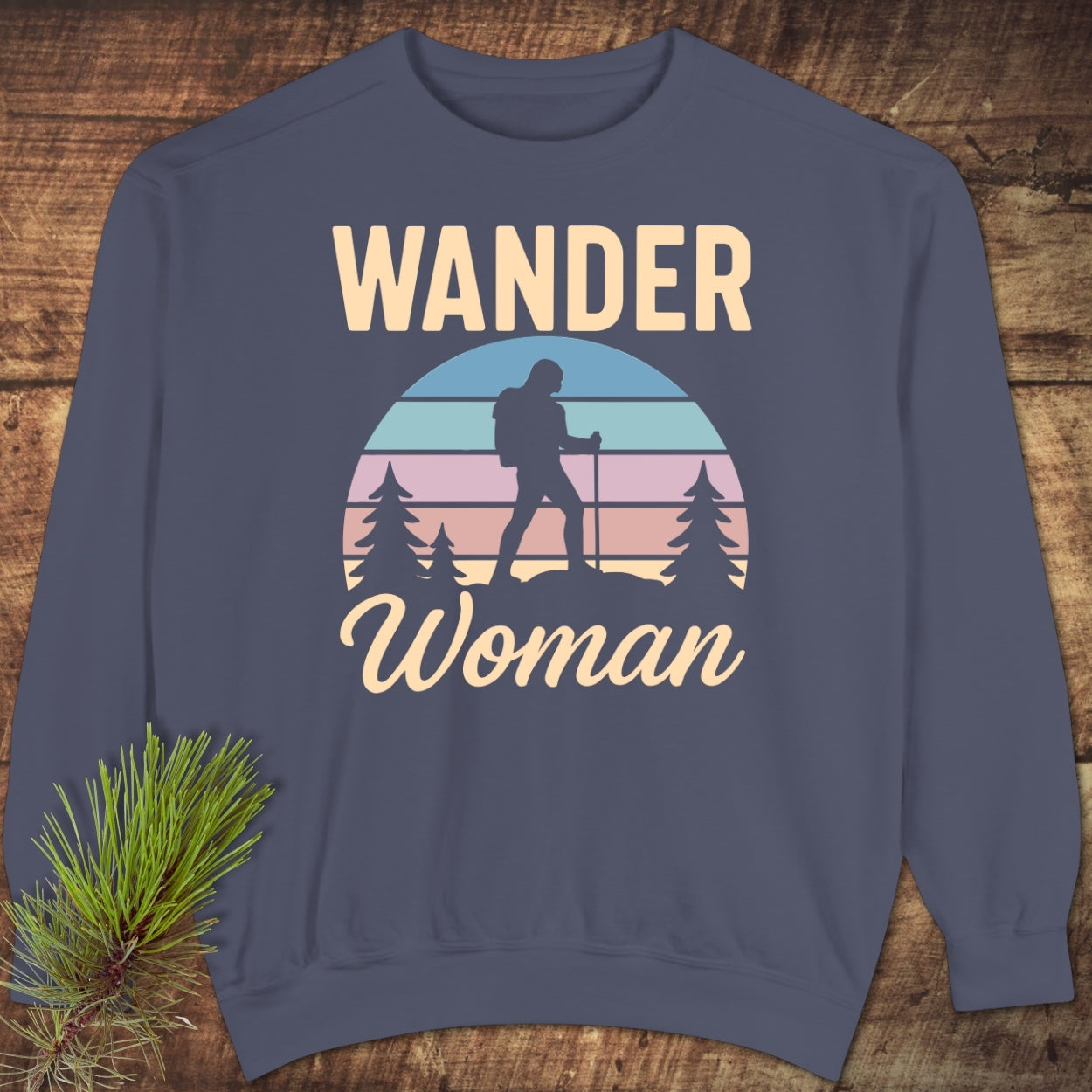 Wander Woman Retro Sweatshirt featuring a hiking-themed design with “WANDER Woman” text and a sunset graphic. Showcasing a relaxed fit, it's crafted from garment-dyed, ring-spun cotton and polyester blend.