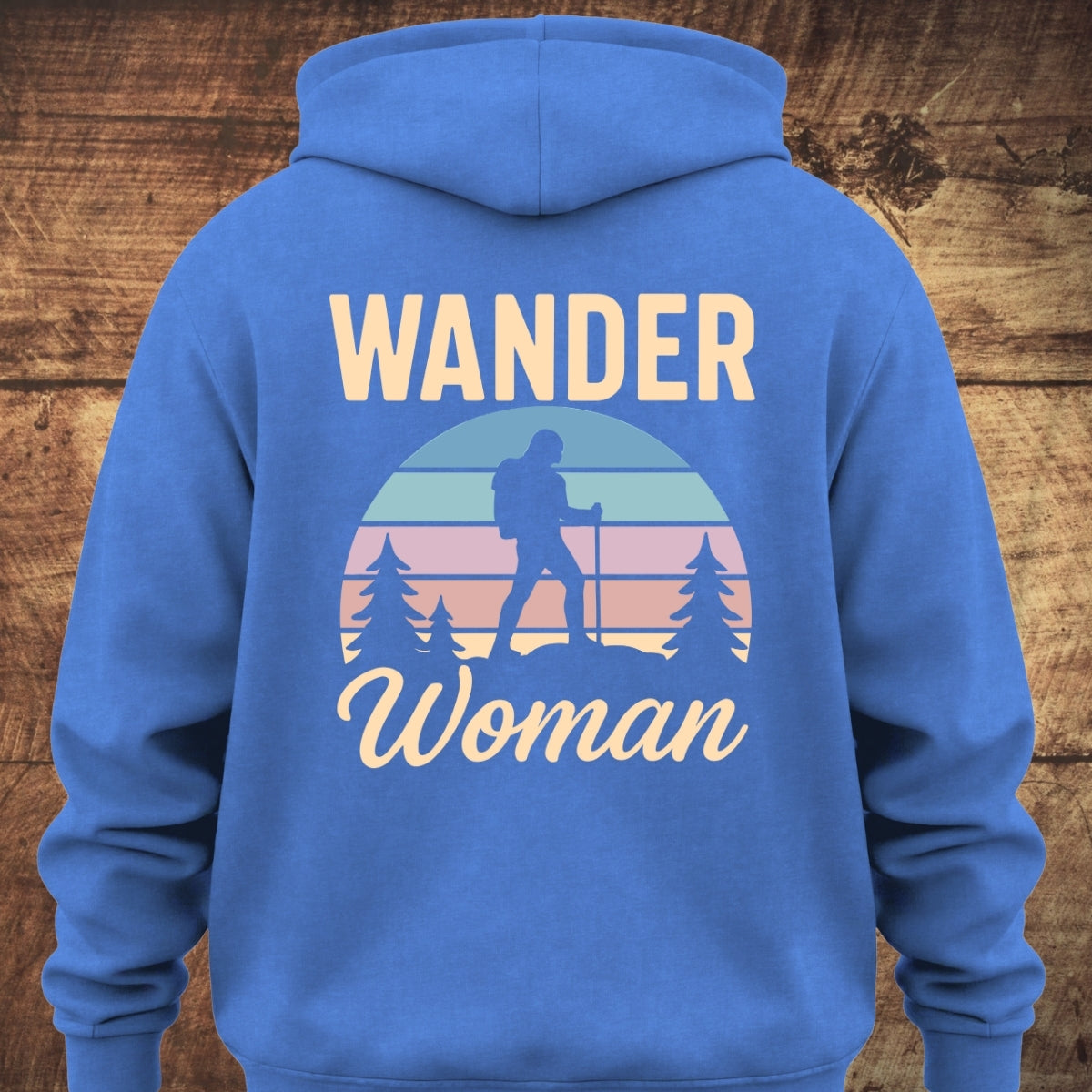 Back of the Wander Woman Retro Hoodie BACKPRINT featuring a stylized outdoor graphic with “WANDER Woman” text and a sunset motif showing a hiker between pine trees.