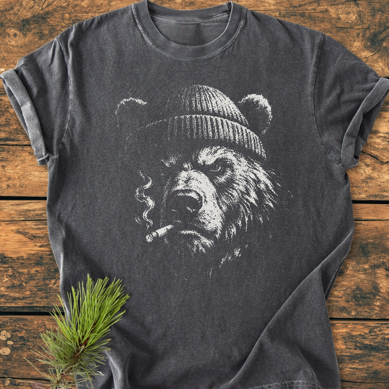 Smoking Bear - Vintage Wash Tee features a charcoal-gray T-shirt with a grizzly bear illustration wearing a beanie and holding a cigarette, showcasing its relaxed fit and soft-washed, garment-dyed cotton fabric.