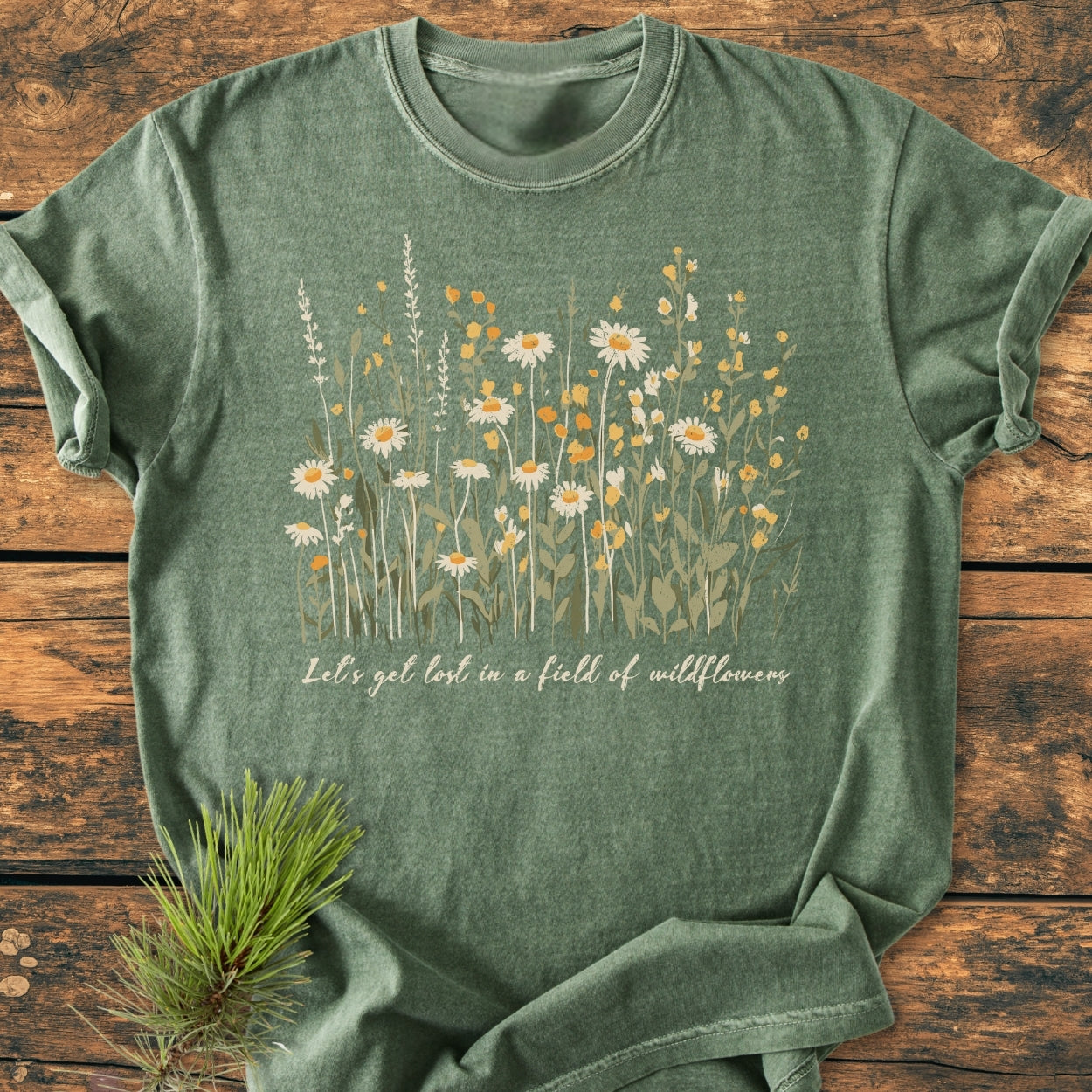 Let's Get Lost In A Field Of Wildflowers - Vintage Wash Tee features heather-green cotton and white-yellow wildflowers print, styled with a pine sprig; soft, relaxed fit, durable ring-spun cotton.