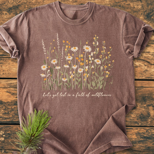 Let's Get Lost In A Field Of Wildflowers - Vintage Wash Tee features daisies and yellow wildflowers on heather brown fabric, styled with a pine sprig. Relaxed fit, soft-washed, durable Comfort Colors 1717.