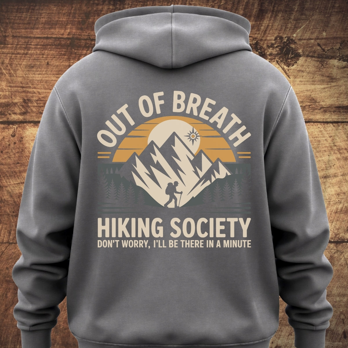 The Out Of Breath Hiking Society BACKPRINT hoodie showcases a stylized outdoor scene with mountains, trees, and a backpacker, complemented by humorous hiking-themed text, ideal for outdoor enthusiasts.