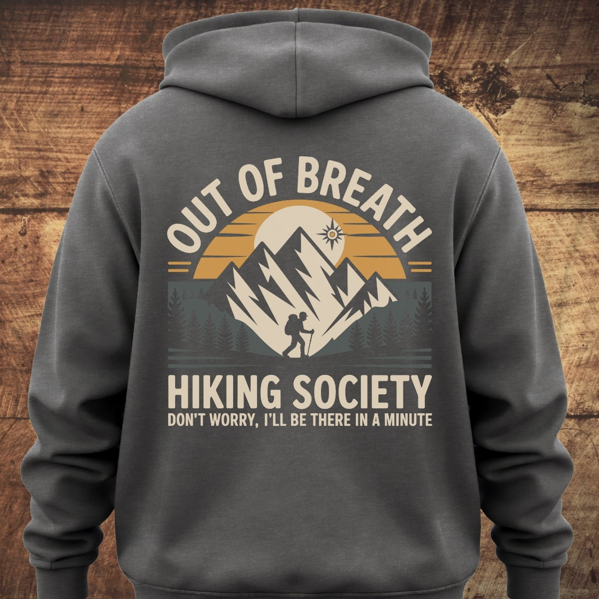 Back of the Out Of Breath Hiking Society hoodie, featuring a mountain range with a hiker and sun, slogan, and tagline. Ideal for outdoor adventures with a soft, relaxed fit.