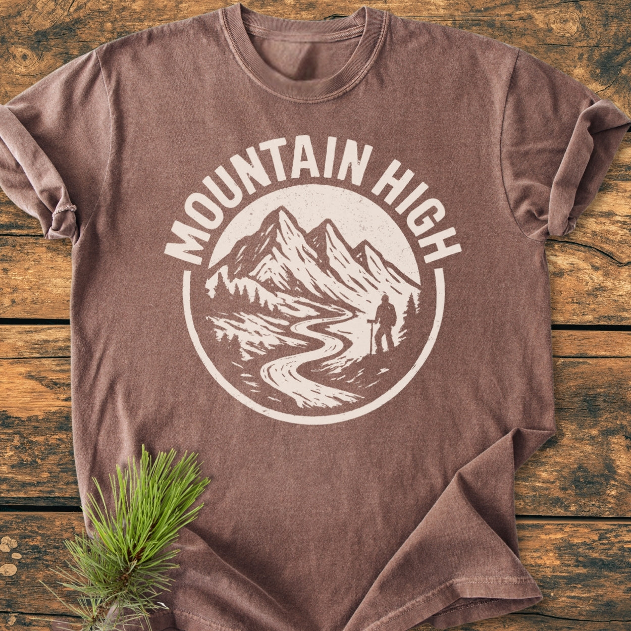 Mountain High - Vintage Wash Tee displays a circular graphic of mountains, a river, and a hiker, enhancing the rustic appeal of this soft, relaxed-fit, ring-spun cotton T-shirt.