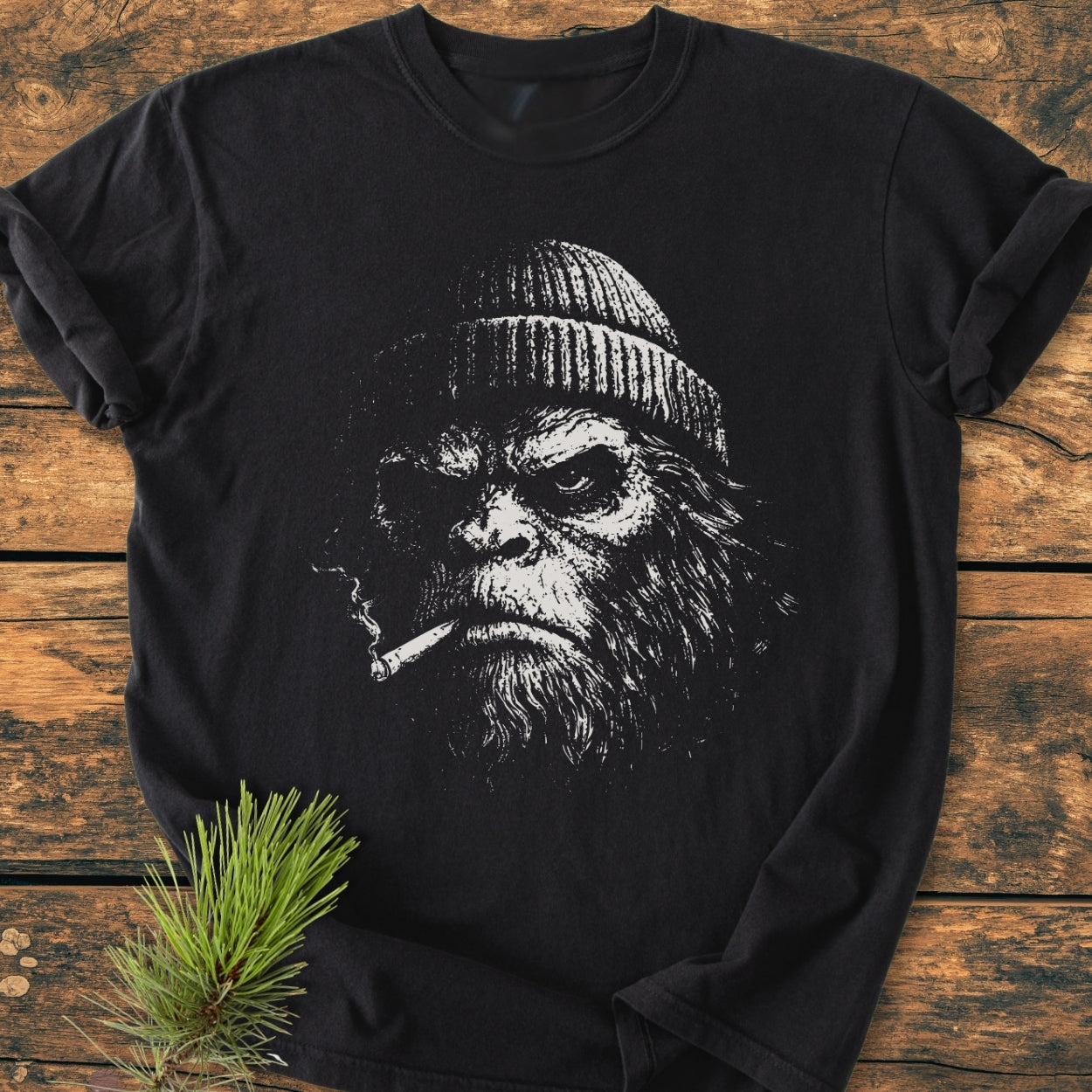 The Slow Burn Club - Vintage Wash Tee features a gritty, hand-drawn bearded face with a beanie and cigarette, printed on a black, relaxed-fit T-shirt, styled with a pine sprig.