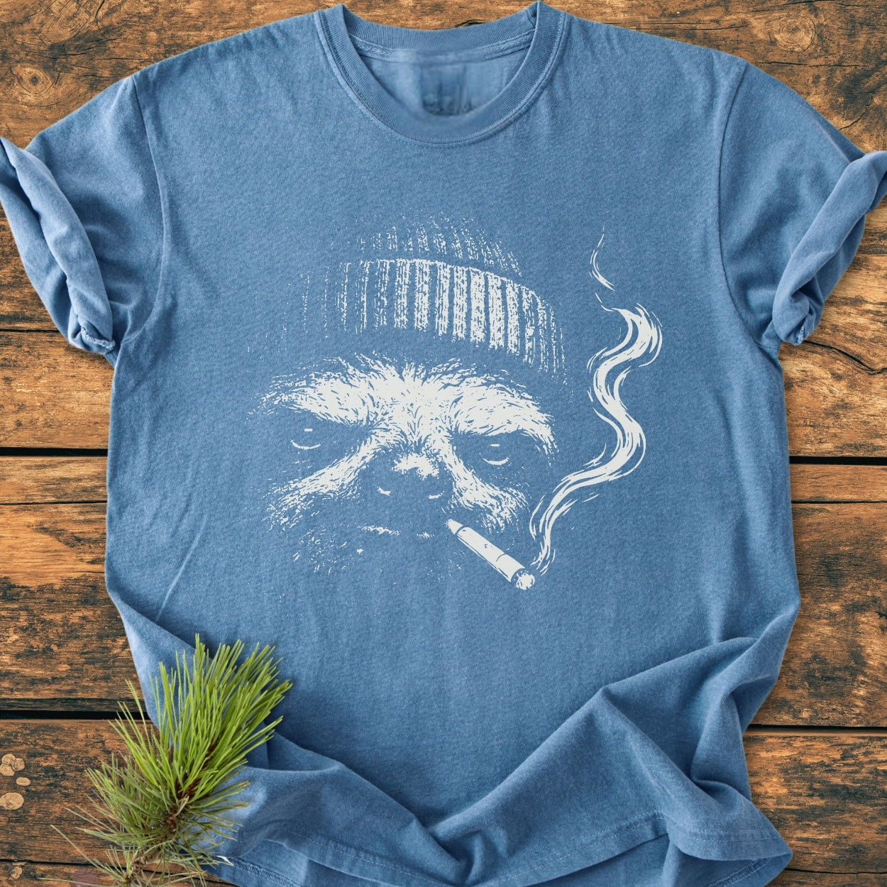 No Rush Club - Vintage Wash Tee featuring a stylized sloth in a beanie with a cigarette, laid flat on wood. Soft, garment-dyed fabric enhances comfort and durability.