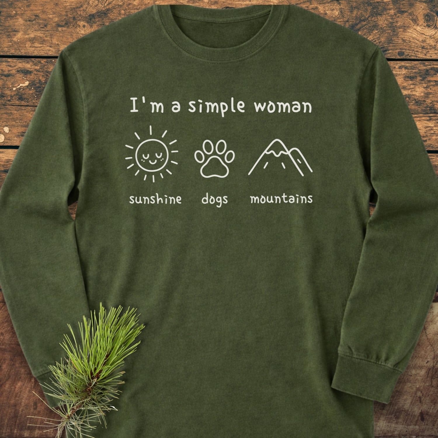 I'm A Simple Woman - Sunshine, Dogs, Mountains Long-Sleeve Tee on rustic wood, featuring white icons of a sun, paw print, and mountains. Made from soft 100% ring-spun cotton with a relaxed fit.