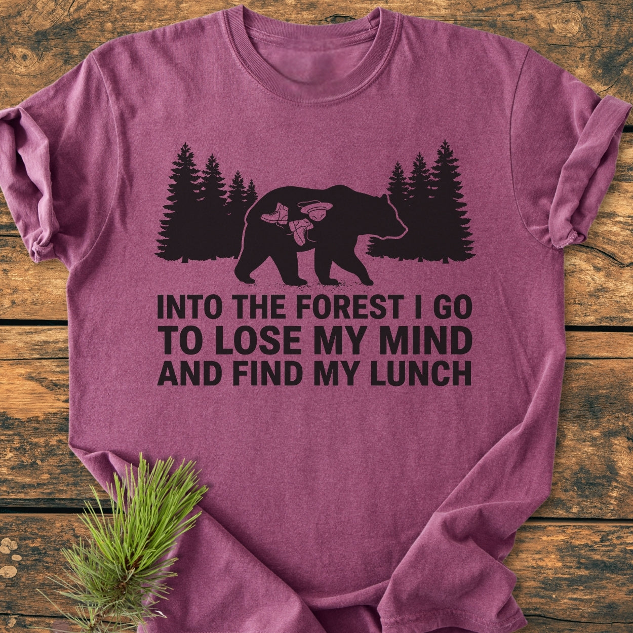 Into The Forest Bear - Vintage Wash Tee features a bear silhouette with pine trees and hiking boots on heather-purple fabric, complemented by an adventurous slogan, embodying the Comfort Colors 1717's relaxed, durable design.
