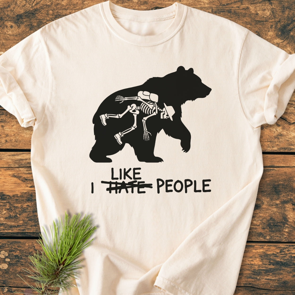 I Hate People - Vintage Wash Tee: Cream T-shirt with a bear silhouette graphic carrying a human skeleton and humorous text alteration, showcasing Comfort Colors' relaxed, durable, 100% ring-spun cotton design.