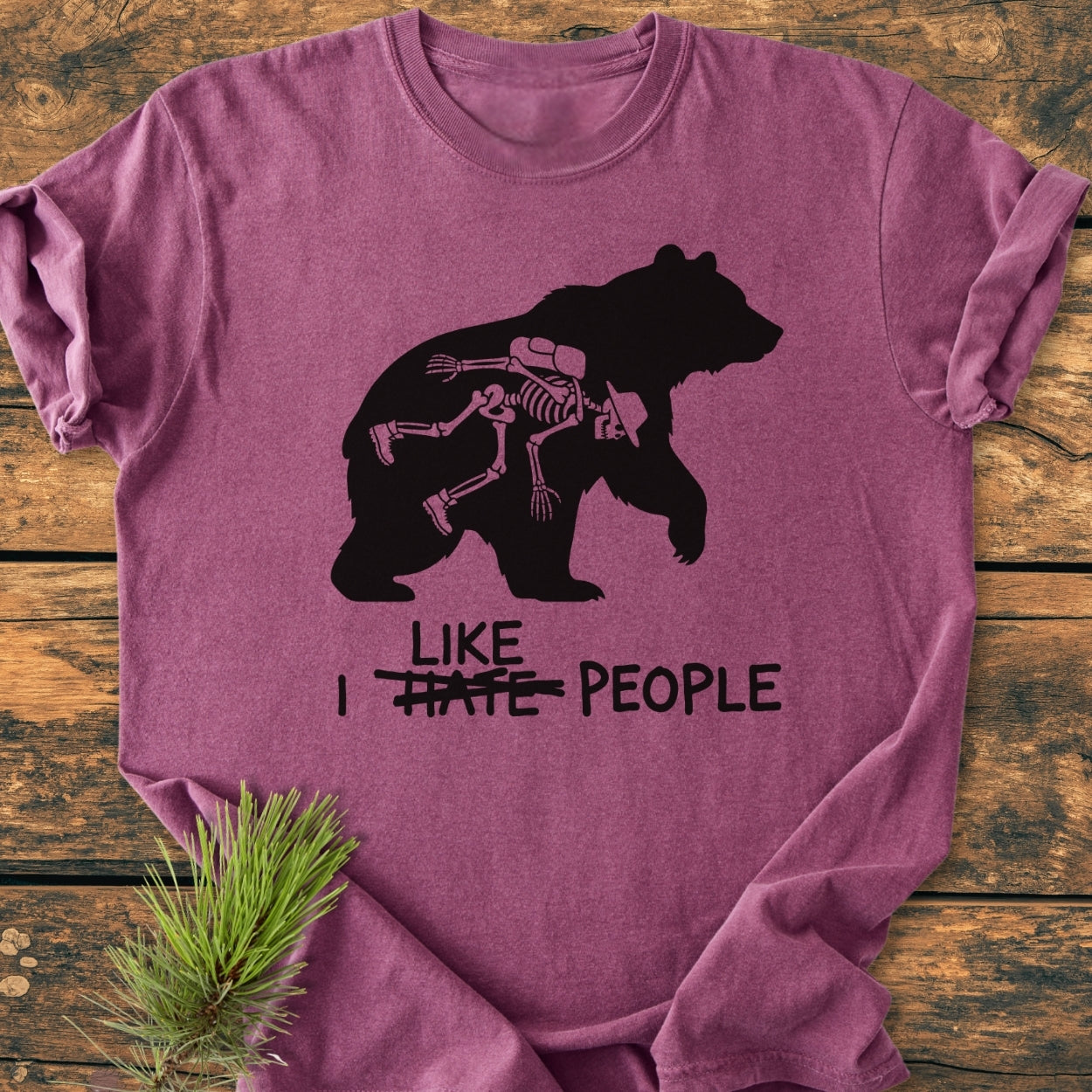 Purple T-shirt featuring a cowboy-riding skeleton inside a bear silhouette with the phrase I like people from the I Hate People - Vintage Wash Tee collection, emphasizing comfort and durability.