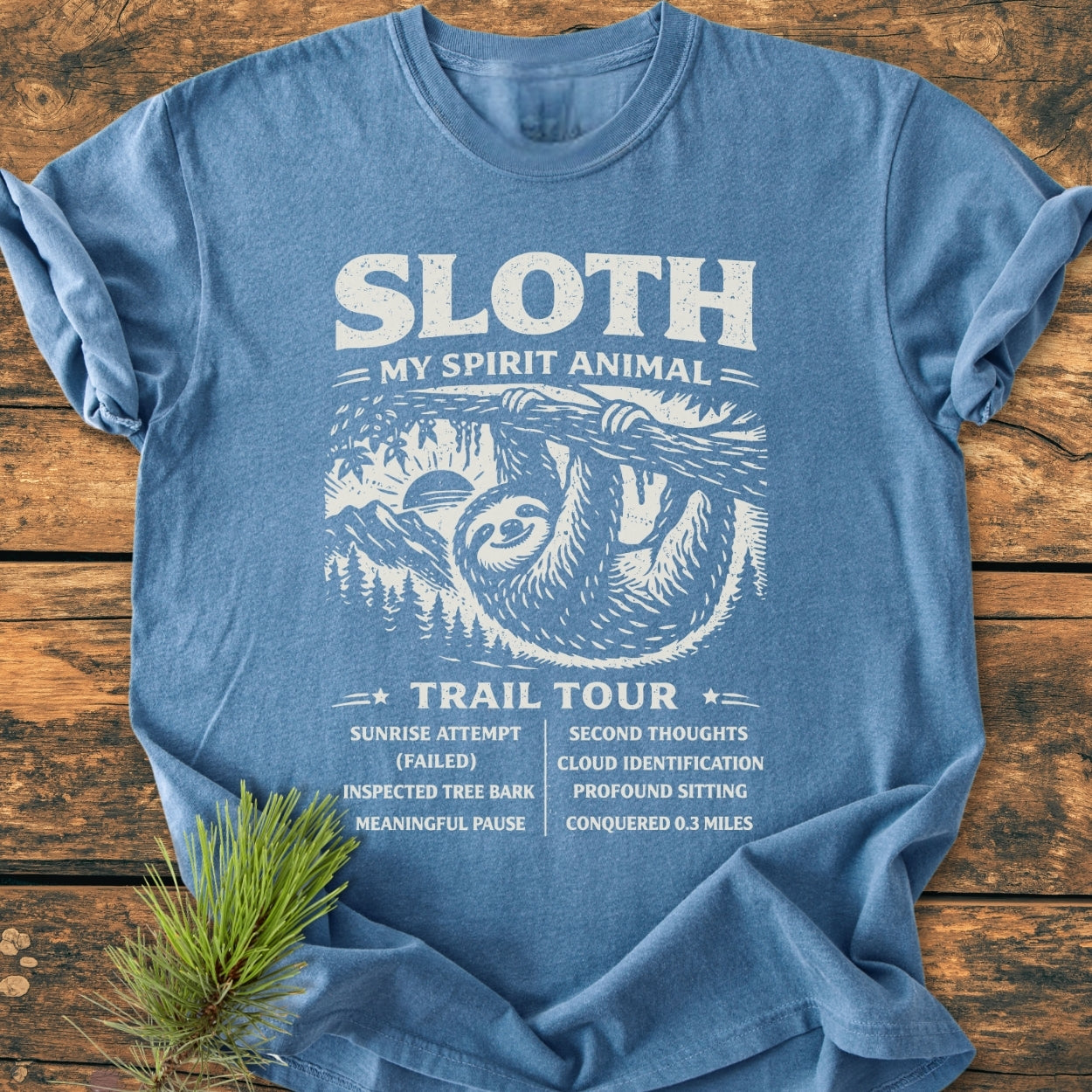Heather-blue Sloth Spirit Animal Tour - Vintage Wash Tee featuring a distressed white graphic of a sloth on a tree branch with playful itinerary; soft, relaxed fit, durable garment-dyed fabric.
