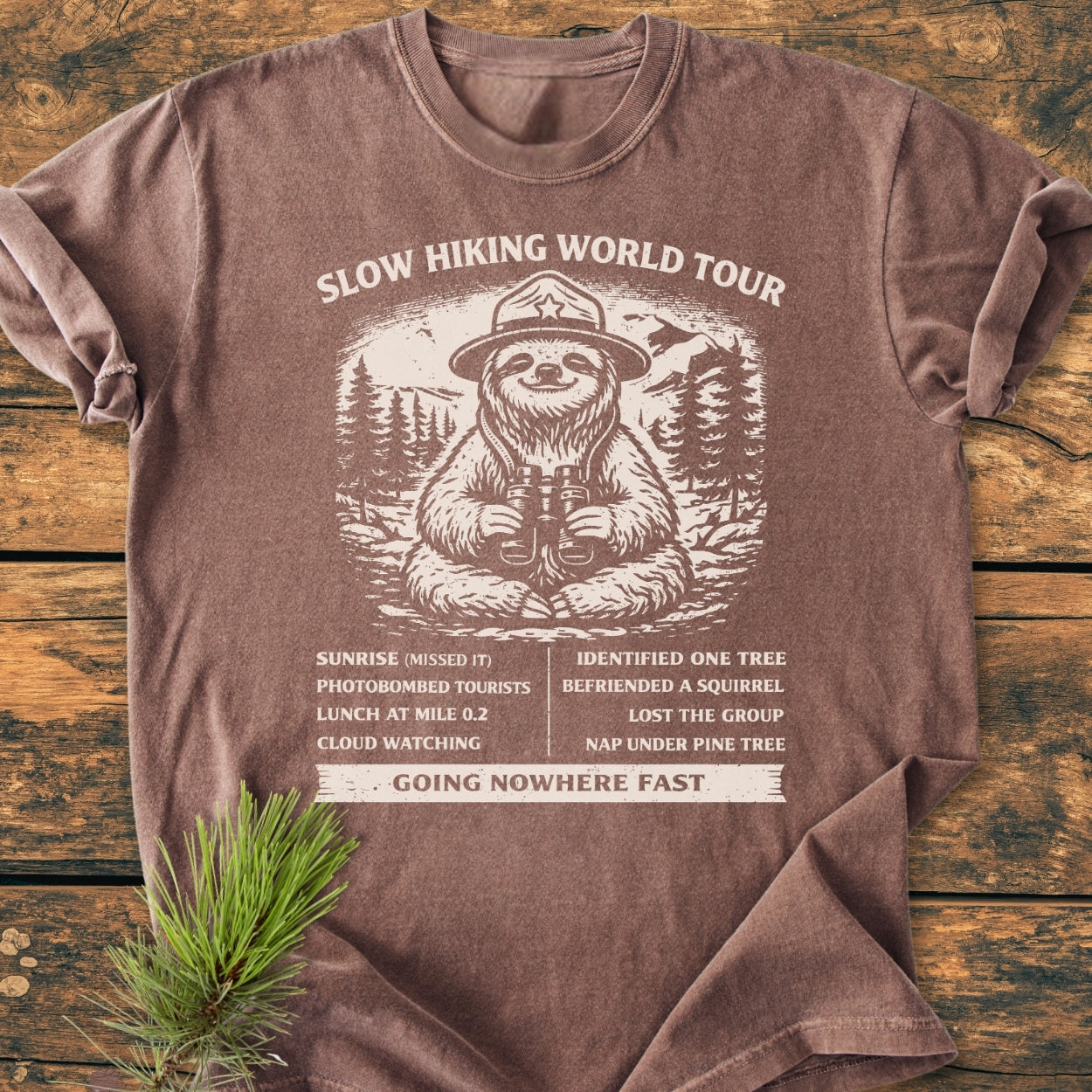 Slow Hiking World Tour - Vintage Wash Tee features a sloth graphic with whimsical itinerary, offering a relaxed fit and soft, durable cotton, perfect for casual wear and outdoor adventures.