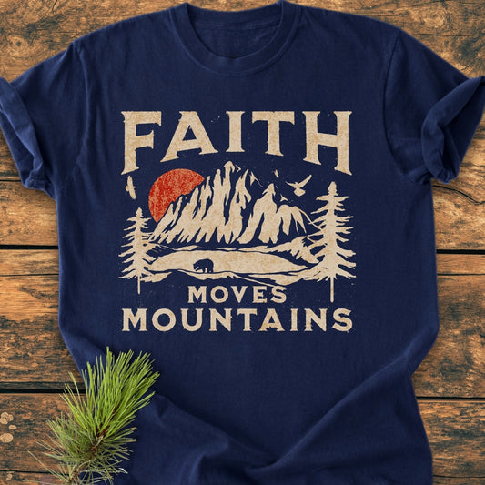 Faith Moves Mountains - Vintage Wash Tee features a distressed cream design with a mountain landscape, red sun, and bear silhouette on a navy-blue, soft-washed, relaxed-fit Comfort Colors T-shirt.