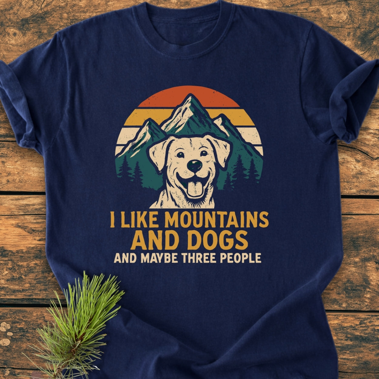 Navy-blue I Like Mountains And Dogs - Vintage Wash Tee featuring a retro mountain scene with sunset, pine trees, and a dog's head. Slogan printed below: I LIKE MOUNTAINS AND DOGS AND MAYBE THREE PEOPLE.