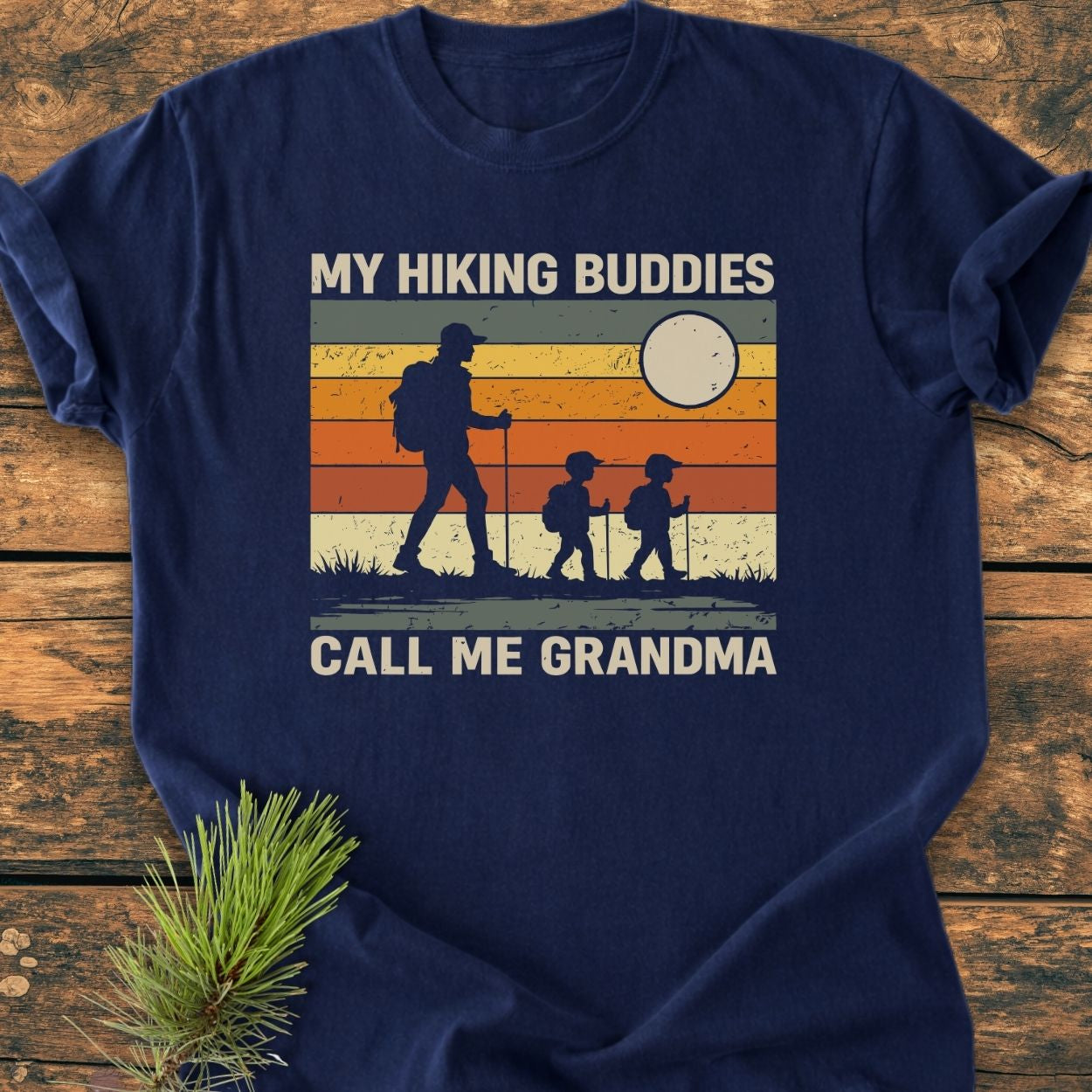 My Hiking Buddies Call Me Grandma - Vintage Wash Tee features a hiker with children against a retro sunset, emphasizing durable Comfort Colors' soft, garment-dyed cotton in a relaxed fit.